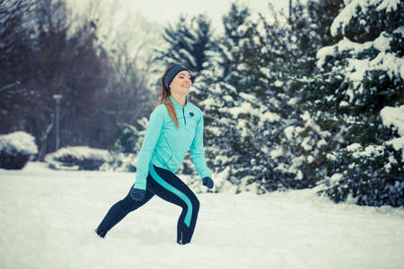 Girl exercising in park. Winter sports, outdoor fitness, fashion, nature workout, health concept.
