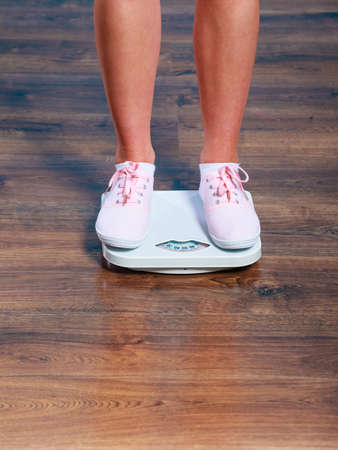 Slimming diet weight loss. Young woman female legs feet on weighing scale Healthy lifestyle concept.