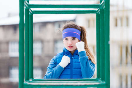 Outdoor sport exercises, sporty outfit ideas. Woman wearing warm sportswear urban street training exercising outside during winter.の写真素材