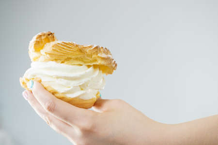Sweets, junk food, sugar temptation on diet concept. Woman holding sweet delicious cream cupcake