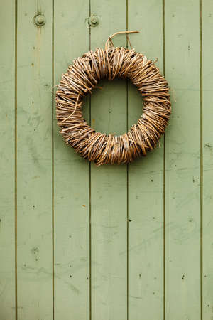 Handmade decorative objects concept. Rounded wicker decoration hanging on wooden wall