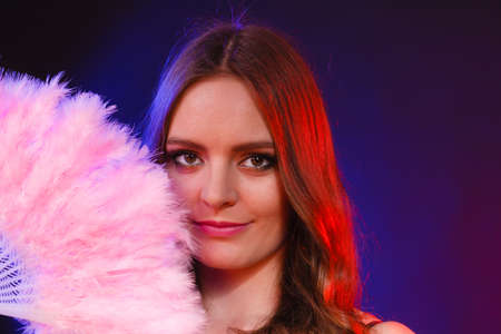 Woman beauty female face eyes makeup holding carnival feather fan in hand. Party new year...