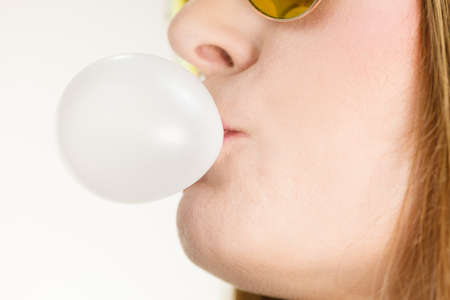 Woman casual style teen girl sunglasses doing bubble with chewing gum closeup. Youth styleの写真素材