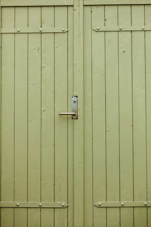 Details in traditional achitecture concept. Closeup of big green oldfashioned wooden doors.