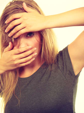 Emotions, embarrassment, awkwardness gestures concept. Ashamed blonde woman covering her face with hands. Studio shot on white background.の写真素材
