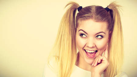Education, teenage adolescence, happiness concept. Happy blonde teenager student girl with ponytailsの写真素材