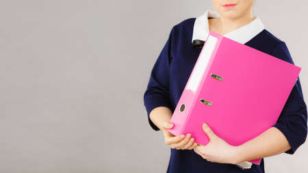 Happy positive accountant business woman holding binder with documents, enjoying her work.の写真素材