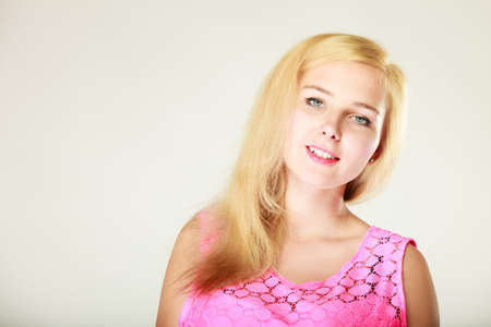 Dyeing, hairstyling, feminity, female beauty concept. Happy blonde woman in pink top. Studio shot on white background.の写真素材