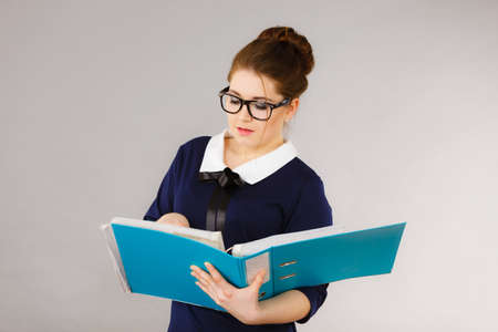 Focused business woman writing something down, thinking about problem solution and new ideas.