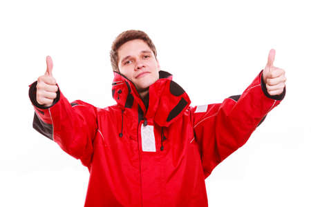 Man wearing protective clothing. Young male in red oilskin. Adventure danger waterproof action outdoor concept.の写真素材