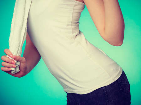 Workout, hygiene concept. Woman holding a towel, part of body studio shot on blue backgroundの写真素材