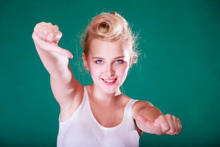 Symbols, gestures concept. Smiling young woman with pinup hair making thumbs up gesture. Studio shot...