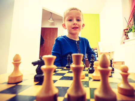 Intelligent, smart ass kids, games good for brain intelligence concept. Young kid boy playing chess and having fun.の写真素材