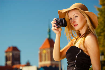 Tourism, artistic, elegant fashion. Woman in elegant outfit and sun hat taking pictures.の写真素材