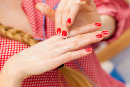 Body care concept. Woman applying moisturizing hand cream on hands and nails.の写真素材