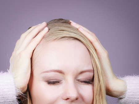 Happiness, human reactions, face expressions concept. Happy blonde woman holding head out of joy