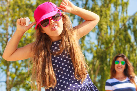 Play and fun in summer. Adorable girl daughter having fun with her mommy. Family spending time together on beach seaside.の写真素材