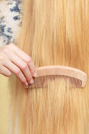 Haircare, choosing best conditioner for tangled hairstyle concept. Blonde woman brushing her hair...