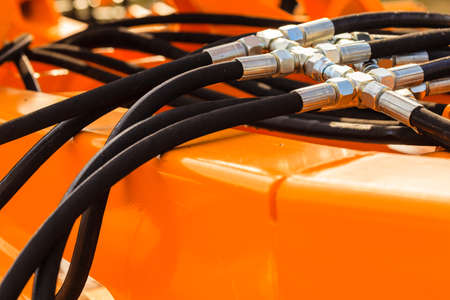 Industrial detailed pneumatic, hydraulic machinery concept. Pump made of steel on orange machine...