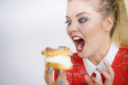 Woman holding sweet cupcake cake dessert with cream, she wants to eat it.の写真素材
