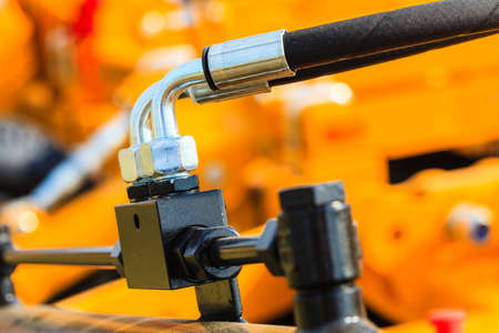 Industrial detailed pneumatic, hydraulic machinery concept. Pump made of steel on orange machine...