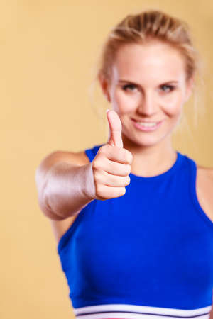 Sport, exercising and diet concept. Woman relaxing after doing sports. Fitness female in sportswear showing thumb up smilingの写真素材