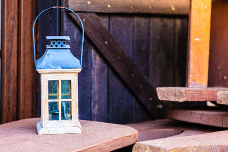 Vintage village decorations concept. Little tealight blue and white lantern on wooden boards outsideの写真素材