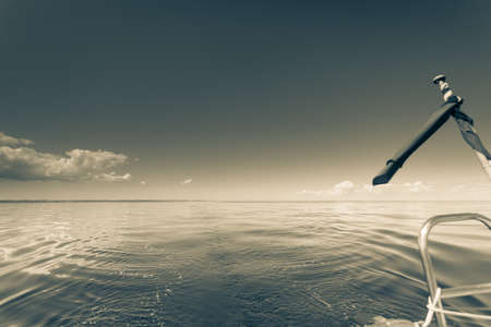 Yachting on sail boat during sunny summer weather on calm sea water. Sporty transportation concept.の写真素材