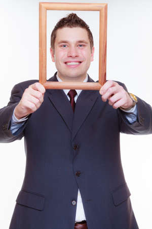 Looking good concept. Business man wearing elegant suit with face in wooden frameの写真素材