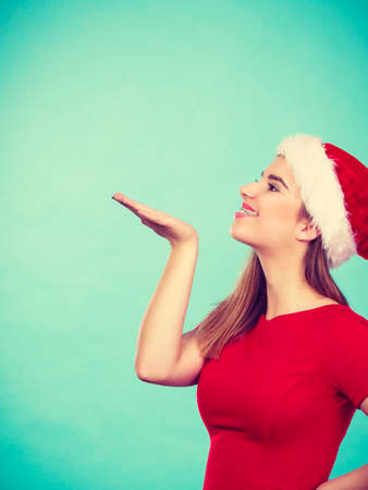 Xmas, seasonal clothing, winter christmas concept. Happy woman wearing Santa Claus helper costume sending air kisses.の写真素材