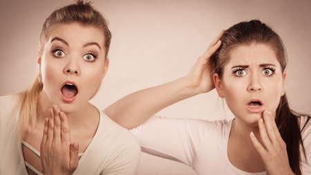 Shock face expressions concept. Closeup of two shocked and amazed women seeing something weird.の写真素材
