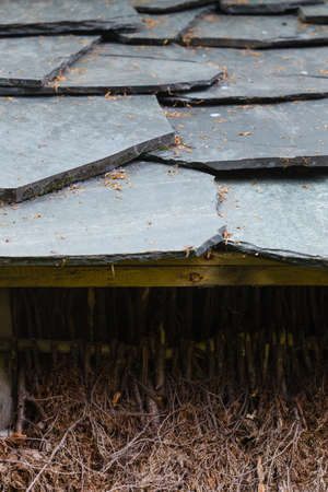 Architecture details concept. Detailed closeup of dark grey stone rock roof tiles.の写真素材