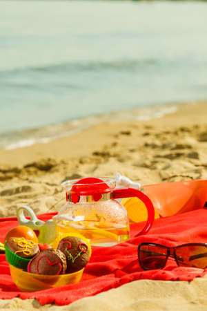 Relaxation during summertime concept. Picnic basket with fruit on red blanket near sea,の写真素材