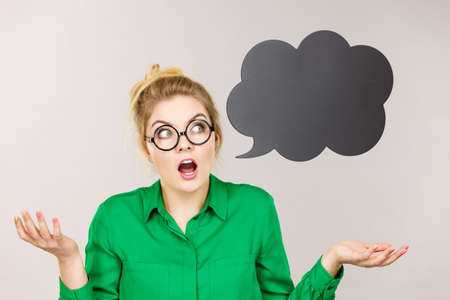 Shocked astonished business woman wearing green shirt with black thinking or speech bubble.の写真素材