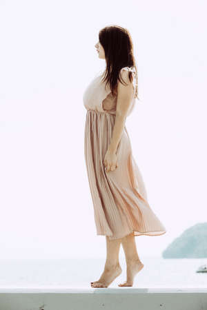 Fashionable clothing, fashion and trends concept. Woman in long dress standing and posing barefoot.の写真素材
