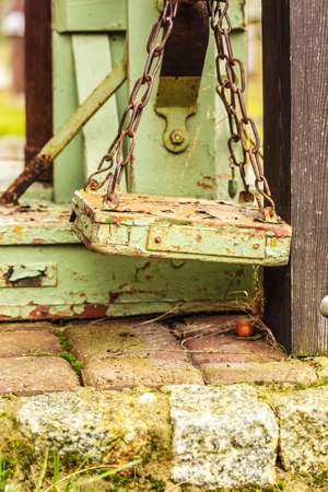 Vintage, antique objects concept. Old fashioned rotten green wooden weighing machine in sunlightの写真素材