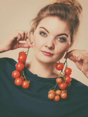Organic vegetables and food concept. Happy positive smiling woman holding fresh cherry tomatoesの写真素材