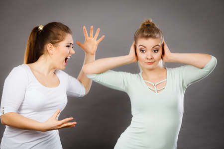 Two women having argue fight being mad at each other. Female telling off, ignorance concept.の写真素材