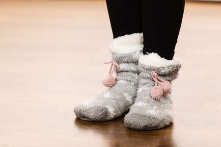 Fashion, clothing, winter time concept. Woman feet wearing woolen warm sock on floor.の写真素材