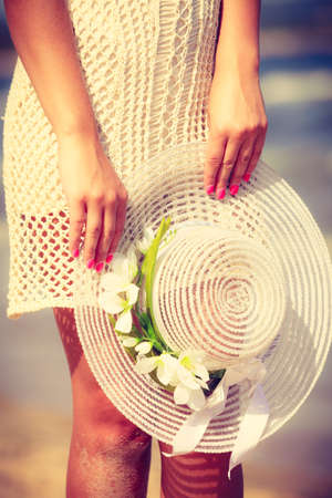 Fashion, clothes and clothing, outfit ideas perfect for summer concept. Unrecognizable woman wearing short white lace dress holding sun hat.の写真素材