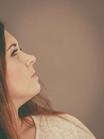 Woman having serious face expression, profile side shot with copyspace on grey background.の写真素材