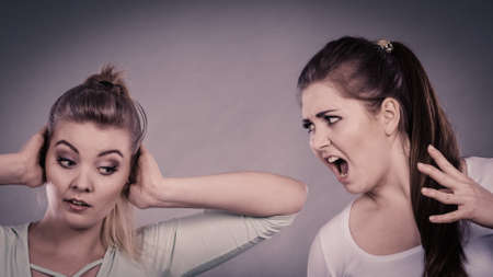 Two women having argue fight being mad at each other. Female telling off, ignorance concept.の写真素材