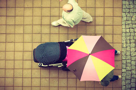 Top view of unrecognizable person walking on city street with purple umbrellaの写真素材