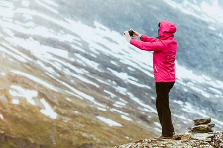Tourism vacation and travel. Female tourist taking photo with camera, enjoying mountains landscape...