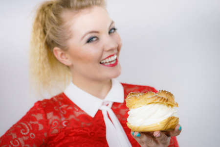 Woman holding sweet cupcake cake dessert with cream, she wants to eat it.