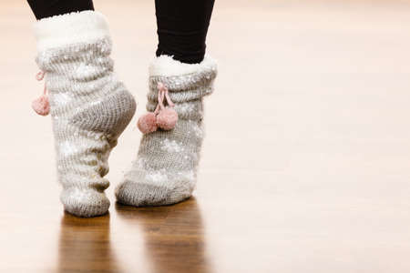 Fashion, clothing, winter time concept. Woman feet wearing woolen warm sock on floor.の写真素材