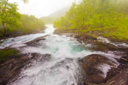 Travel, beauty in nature. Waterfall torrential river along the Aurlandsfjellet mountains in Norway Sogn og Fjordane, foggy hazy summer dayの写真素材