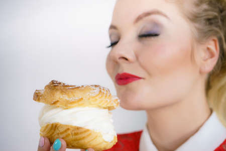 Woman holding sweet cupcake cake dessert with cream, she wants to eat it.の写真素材