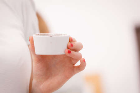Skin care. Female hand holding bowl with clay mud mask to apply on skin face, in bathroom. Girl taking care of her oily compexion. Spa wellbeing.の写真素材