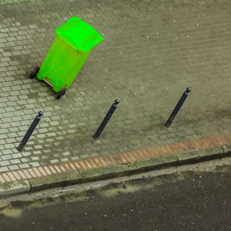 Plastic green wheely bin in the street outside waiting for garbage truck. Top viewの写真素材